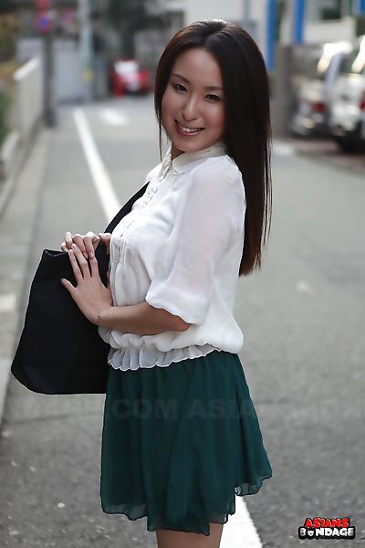 Japanese schoolgirl Anna Sakura pauses in the street to 